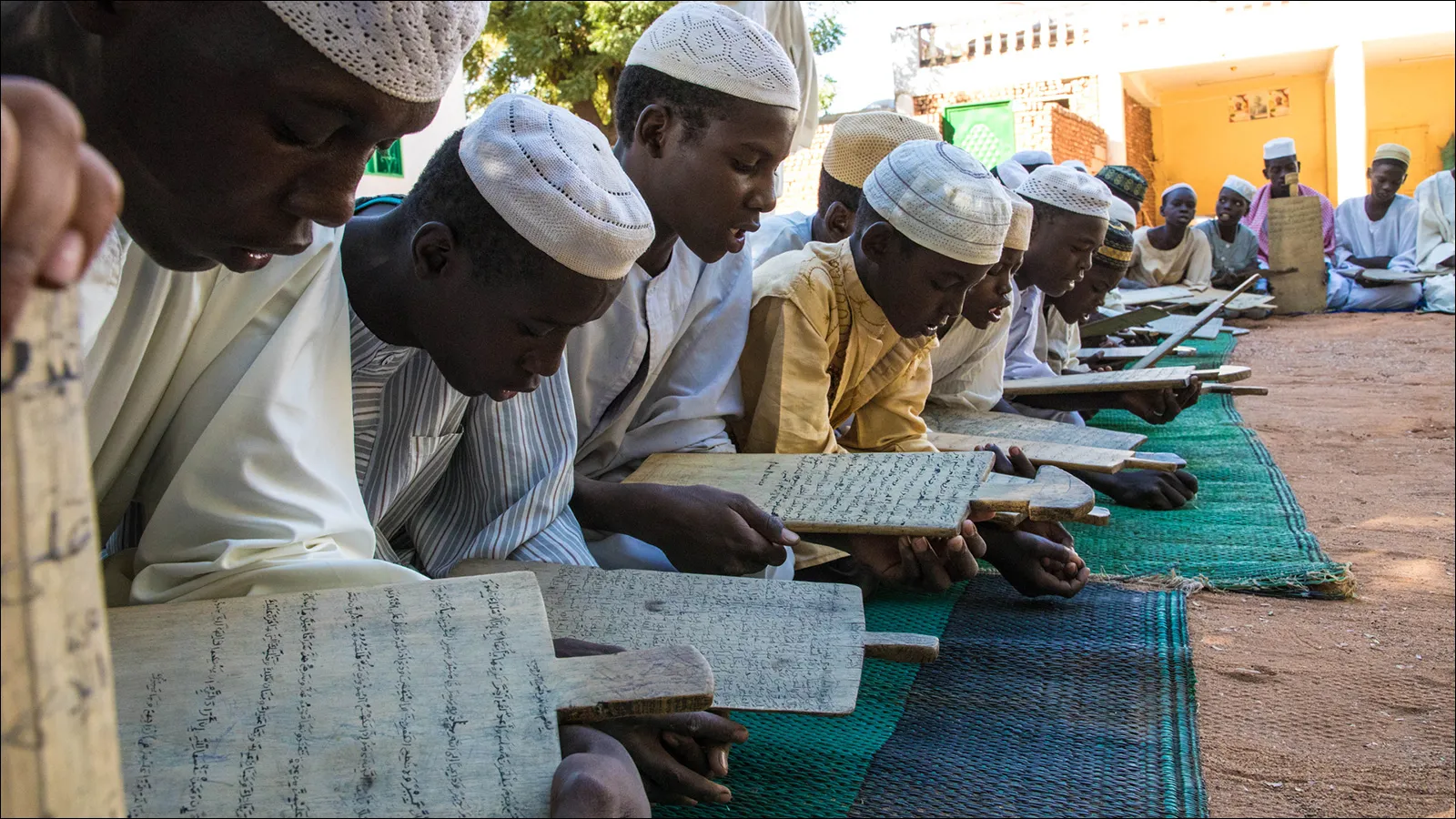 طلاب يحفظون القرآن على الألواح